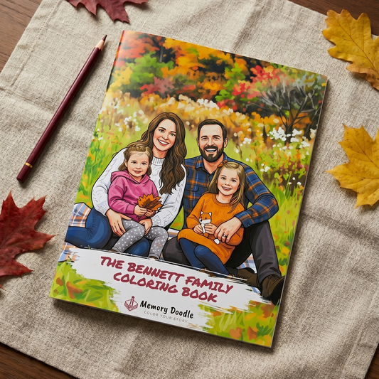A printed coloring book titled "The Bennett Family Coloring Book" lies on a beige linen cloth on a wooden surface, surrounded by autumn leaves and a pencil. The cover shows an illustrated family of four sitting in a colorful field.